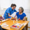 Caring nurse assisting elderly woman with activities