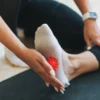 img woman s foot on a mat with massage ball